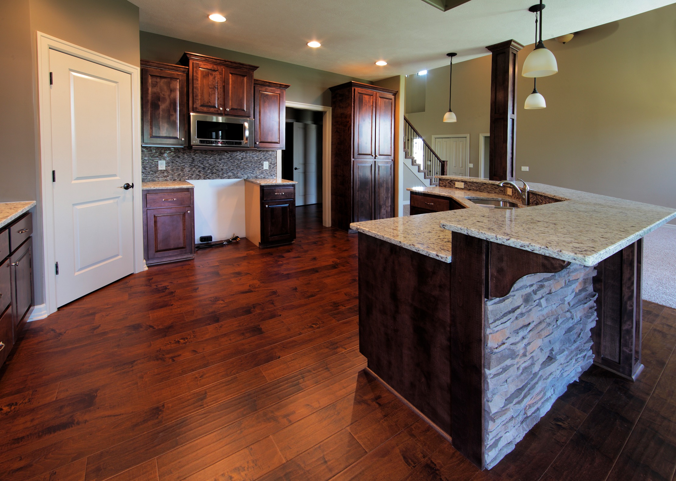 Cherry stained cabinets with stone island accent