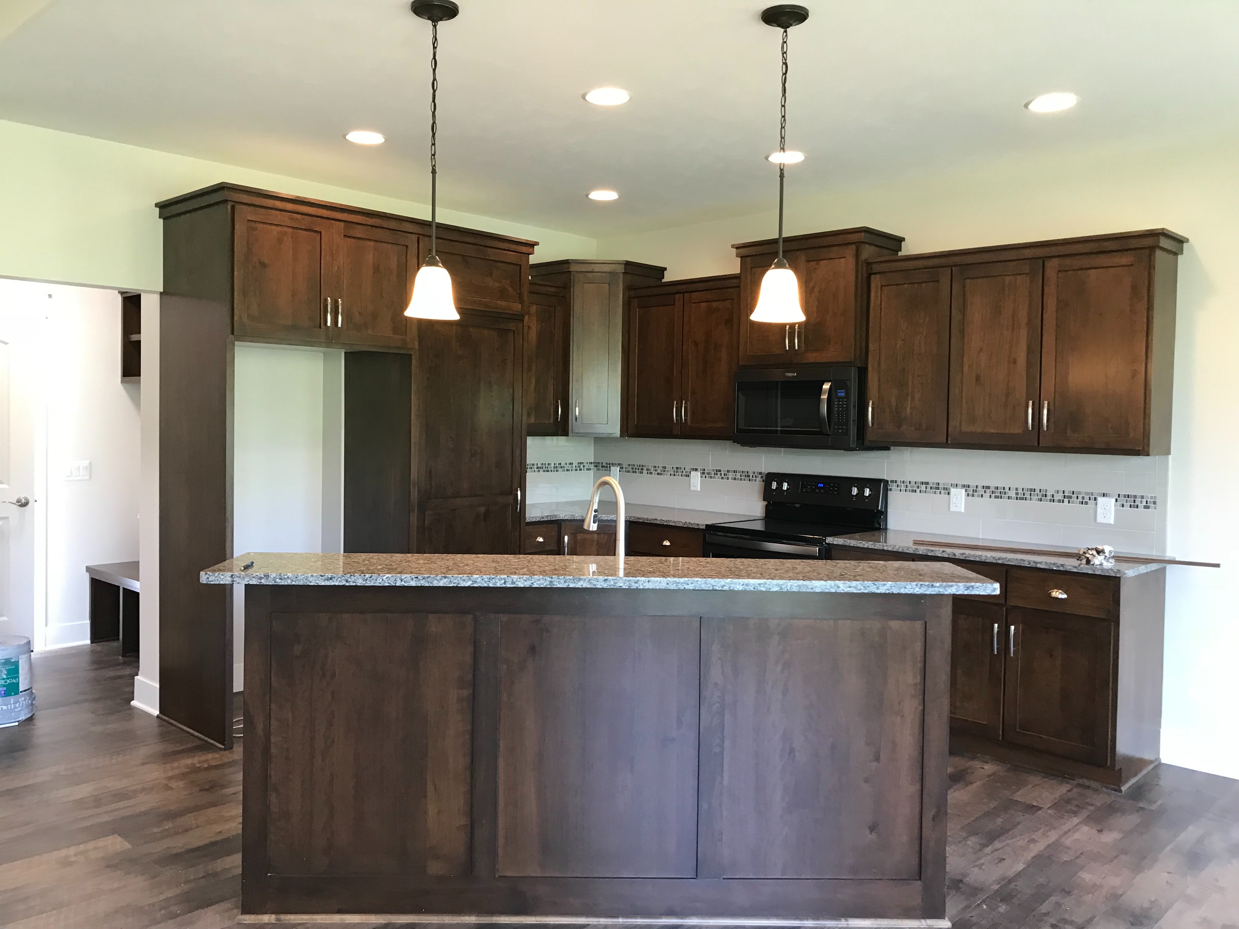 Dark stained wood cabinets with granite island
